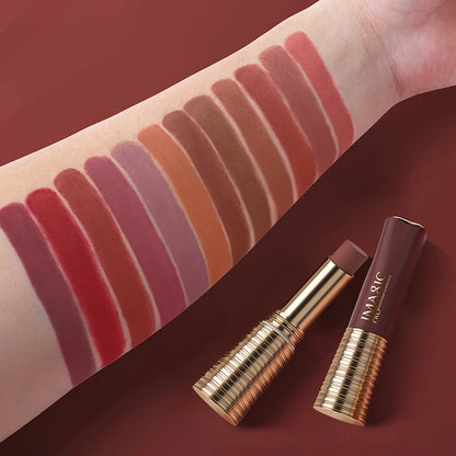 Lipstick swatches on a arm with two lipsticks in front on a red background