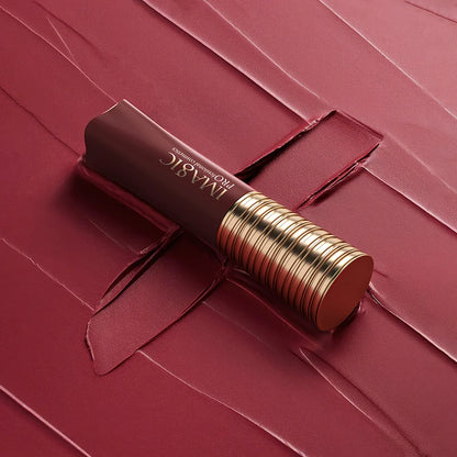 Lipstick with gold accents on a red textured background